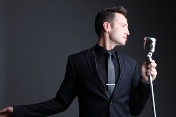 Branden James, tenor, in a black suit at a vintage microphone