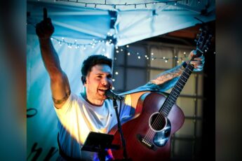 Josh Curnow singing live with an acoustic guitar