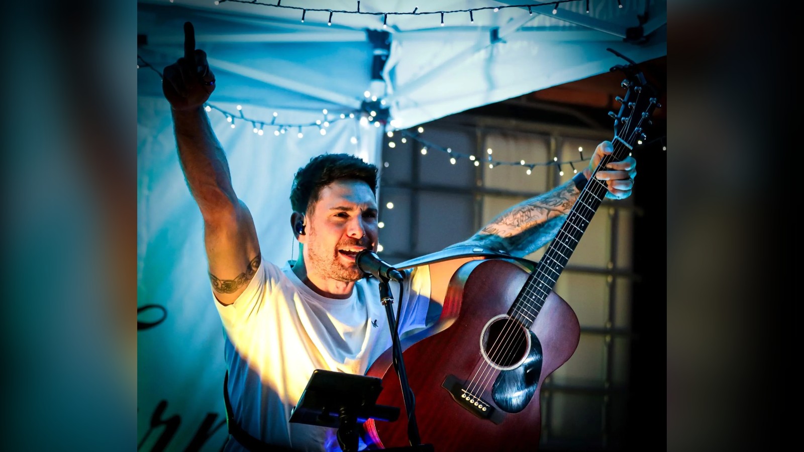Josh Curnow singing live with an acoustic guitar